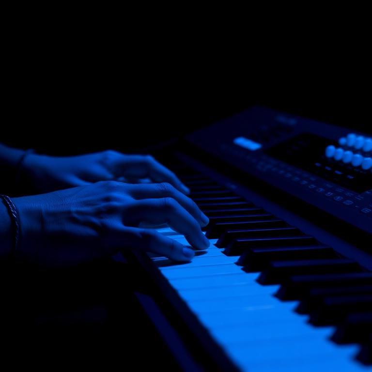 Mãos tocando teclado com luz azul